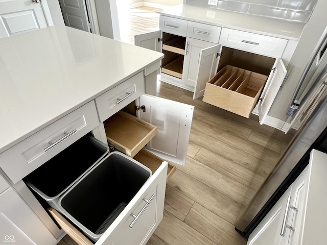 kitchen featuring white cabinets, light countertops, and light wood-type flooring