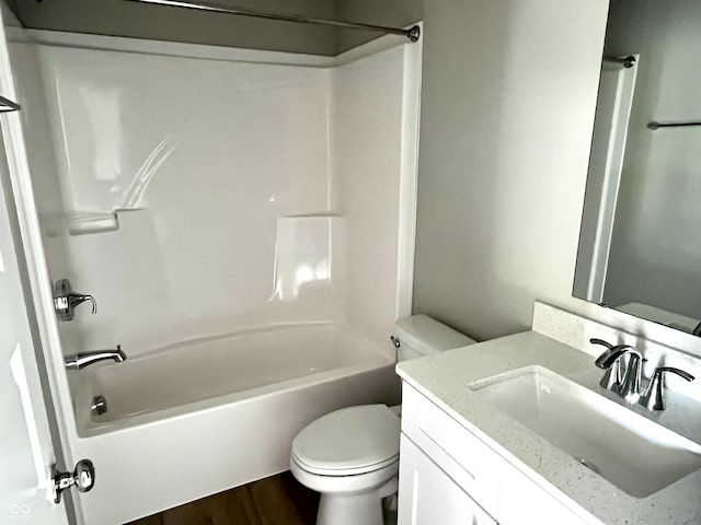 bathroom with wood finished floors, toilet, bathtub / shower combination, and vanity