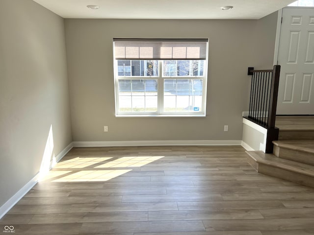 empty room featuring wood finished floors and baseboards