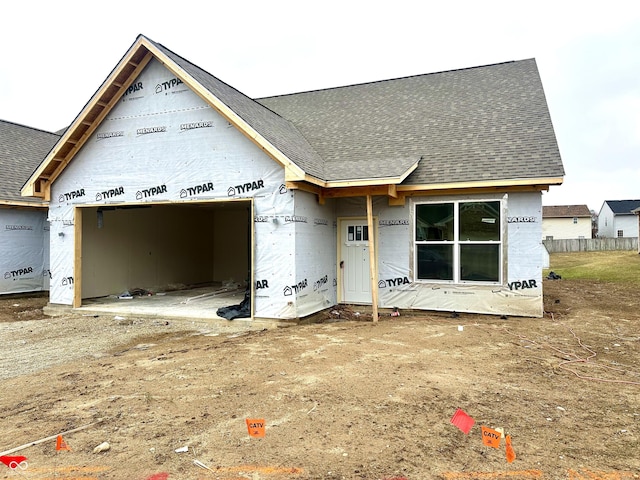 property under construction with a shingled roof and an attached garage