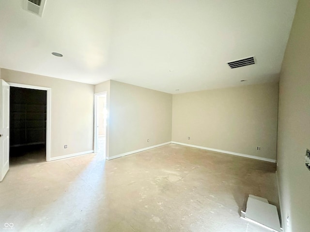 empty room featuring visible vents, baseboards, and concrete flooring