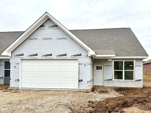 property in mid-construction with an attached garage and a shingled roof