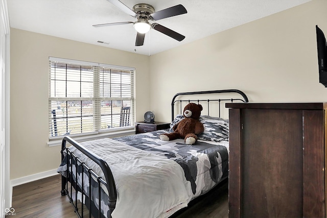 bedroom featuring visible vents, ceiling fan, baseboards, and wood finished floors