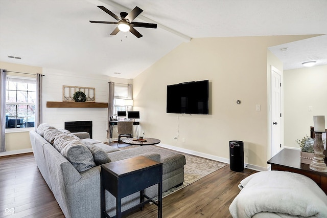 living area featuring dark wood-style floors, a large fireplace, lofted ceiling with beams, and baseboards