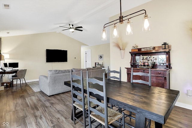 dining space featuring lofted ceiling, wood finished floors, visible vents, and a ceiling fan