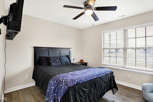 bedroom featuring visible vents, baseboards, and wood finished floors