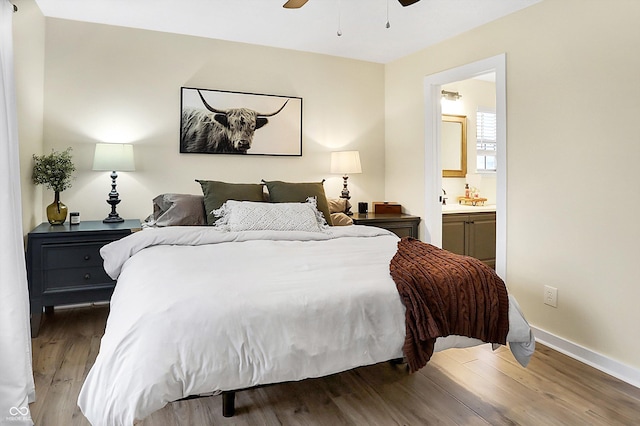 bedroom featuring a ceiling fan, connected bathroom, baseboards, and wood finished floors