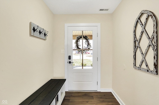 entryway with baseboards, visible vents, and dark wood-type flooring