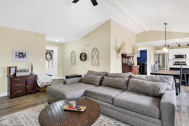 living room with a ceiling fan, baseboards, lofted ceiling with beams, and light wood finished floors