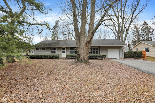 single story home with aphalt driveway and an attached garage