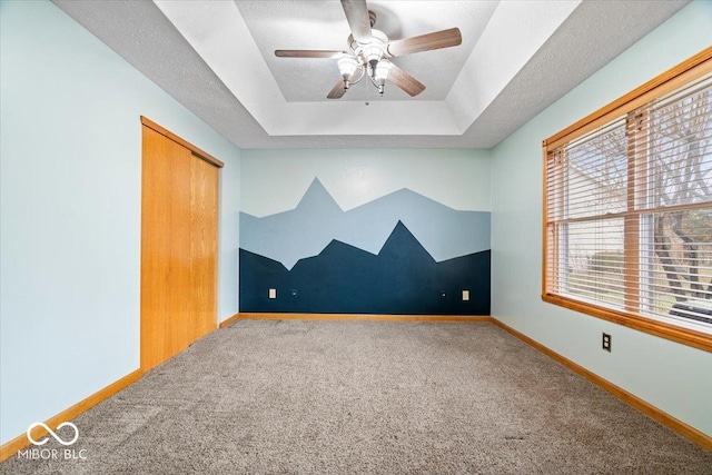 additional living space featuring baseboards, a textured ceiling, ceiling fan, and carpet flooring