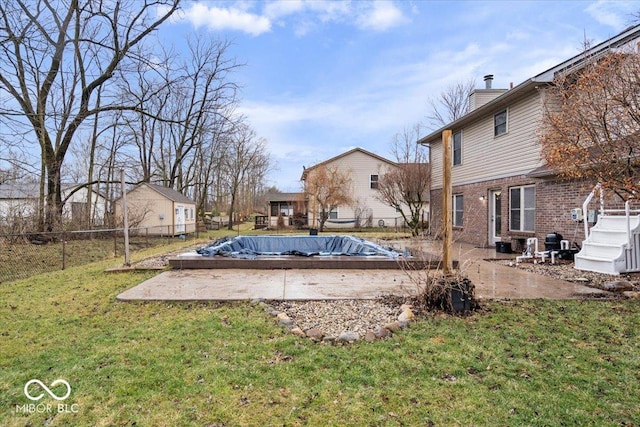 view of pool featuring a patio area, a lawn, and a fenced backyard