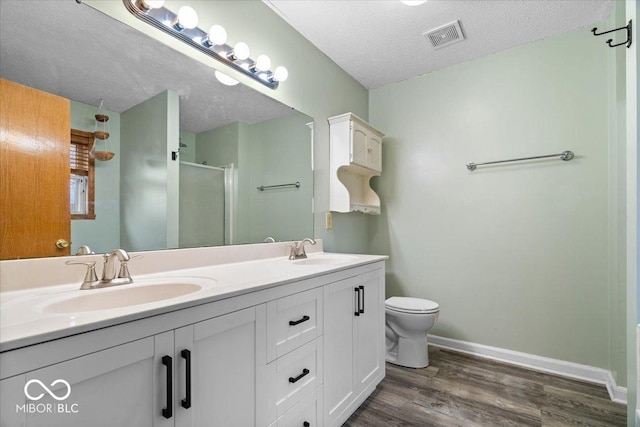 full bathroom featuring visible vents, a stall shower, a textured ceiling, and a sink