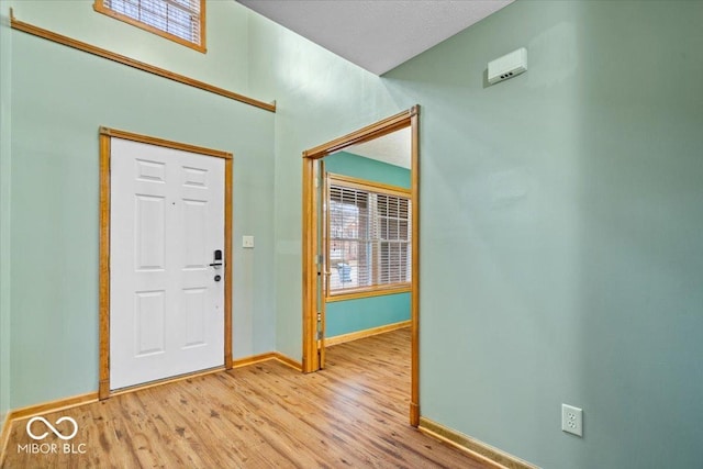 entrance foyer with light wood-style flooring, plenty of natural light, and baseboards