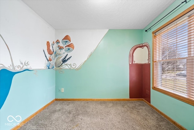 unfurnished room with baseboards, a textured ceiling, and carpet flooring