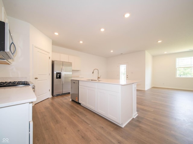 1366 Foxtail Ln, Greenwood, IN 46143 - kitchen featuring appliances with stainless steel finishes, wood finished floors, white cabinetry, an island with sink, and recessed lighting