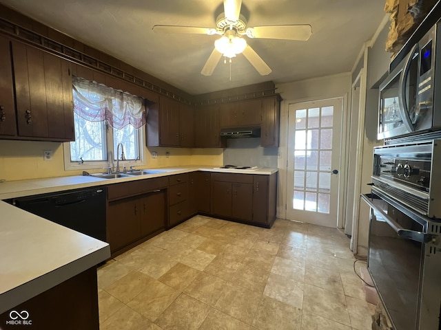 kitchen with light countertops, a sink, black appliances, and extractor fan