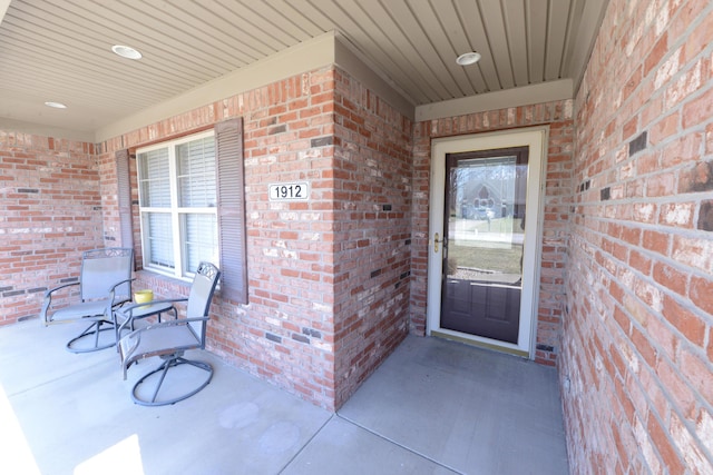 entrance to property featuring brick siding and a porch