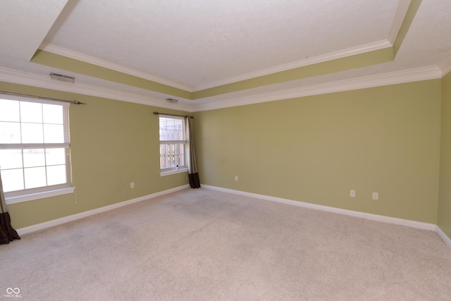 unfurnished room featuring light carpet, visible vents, baseboards, a raised ceiling, and crown molding