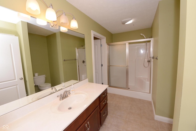 bathroom featuring toilet, a stall shower, baseboards, and vanity