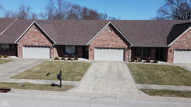 view of front of property featuring an attached garage, brick siding, a shingled roof, concrete driveway, and a front yard