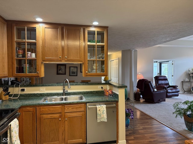 kitchen with decorative columns, brown cabinetry, open floor plan, stainless steel dishwasher, and a sink