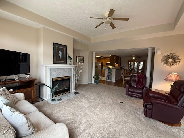 living area with carpet flooring, decorative columns, a textured ceiling, and ceiling fan