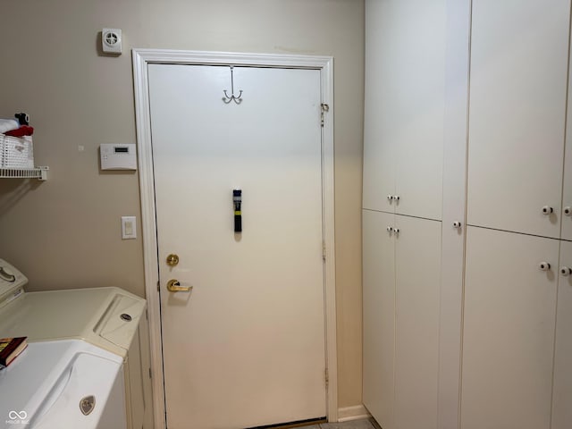 clothes washing area featuring cabinet space and washer and clothes dryer