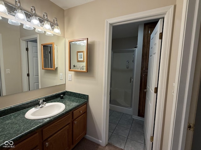 full bathroom with a shower stall, baseboards, tile patterned flooring, and vanity