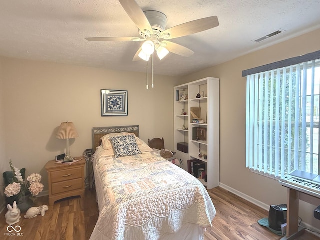 bedroom featuring a textured ceiling, wood finished floors, and visible vents