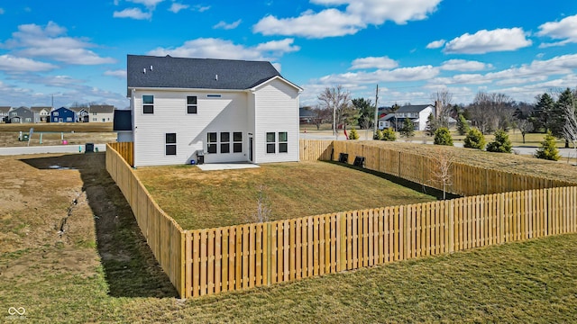 back of house featuring a patio, a lawn, a residential view, and a fenced backyard