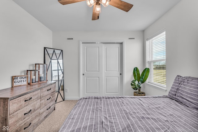 carpeted bedroom featuring visible vents, a ceiling fan, baseboards, and a closet