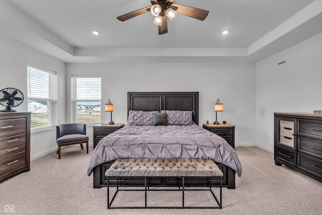 bedroom with a tray ceiling, baseboards, light carpet, and recessed lighting