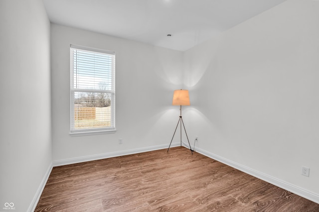 unfurnished room with baseboards and wood finished floors