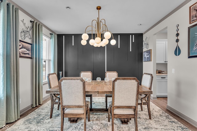 dining space with wood finished floors, baseboards, and a chandelier