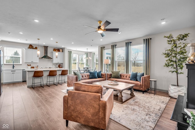 living room with recessed lighting, a textured ceiling, ceiling fan, and light wood finished floors