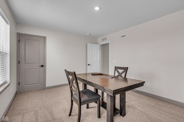 dining room with visible vents, baseboards, and light colored carpet