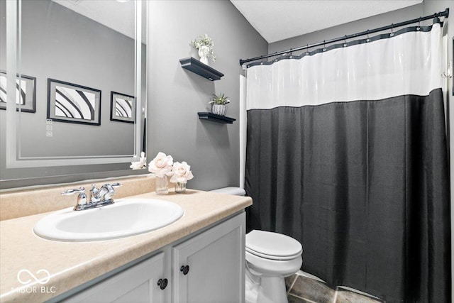 bathroom featuring a shower with shower curtain, vanity, and toilet