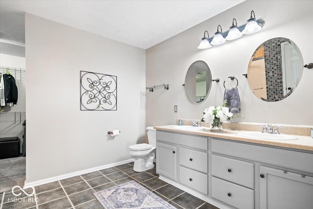 bathroom with a sink, a textured ceiling, and double vanity