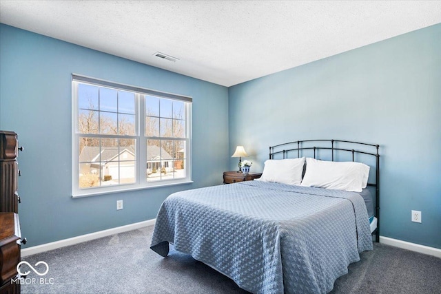 carpeted bedroom featuring baseboards, visible vents, and a textured ceiling