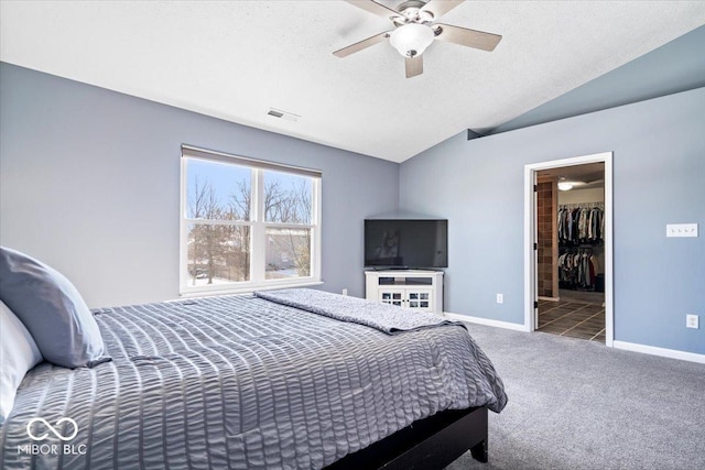 bedroom with carpet floors, lofted ceiling, visible vents, a spacious closet, and baseboards