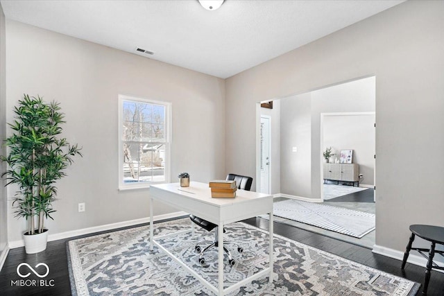 office space with hardwood / wood-style flooring, visible vents, and baseboards