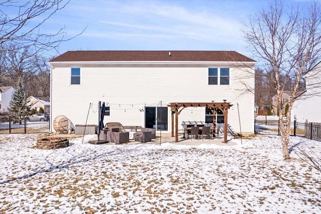 snow covered rear of property featuring an outdoor living space with a fire pit, a fenced backyard, and a pergola