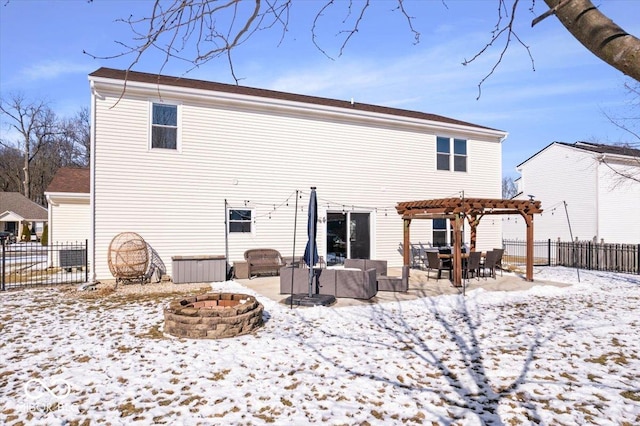 snow covered house featuring an outdoor living space with a fire pit, fence, a patio, and a pergola