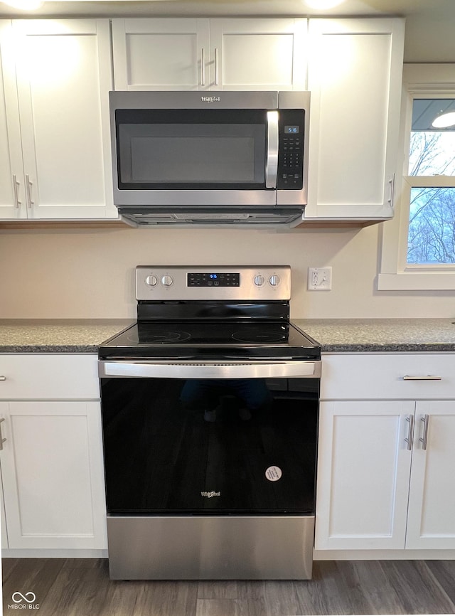 kitchen featuring light countertops, appliances with stainless steel finishes, wood finished floors, and white cabinets