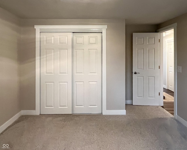 unfurnished bedroom featuring a closet, carpet flooring, and baseboards