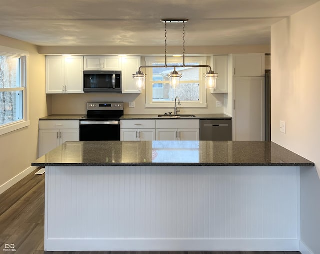 kitchen with dark wood-style flooring, a sink, white cabinetry, baseboards, and appliances with stainless steel finishes