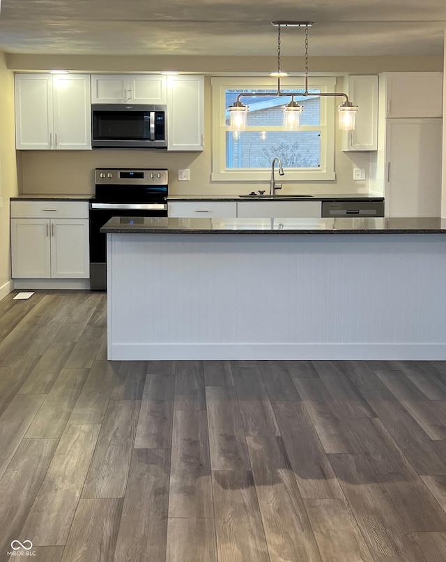 kitchen with stainless steel appliances, white cabinets, a sink, and dark wood-type flooring