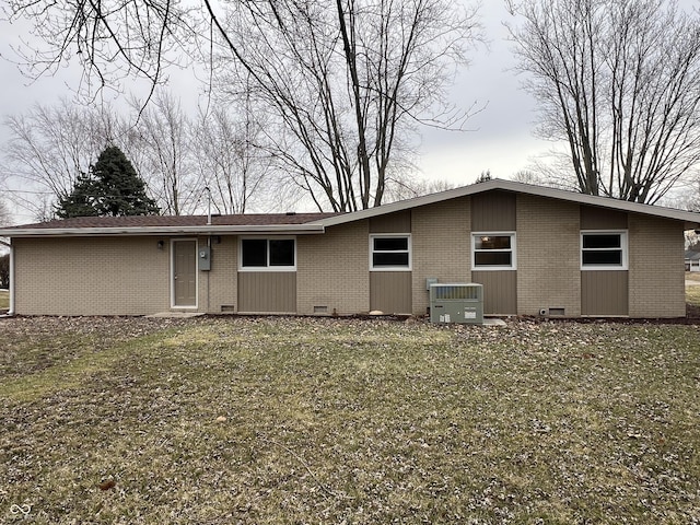 rear view of house with a yard, central AC unit, crawl space, and brick siding