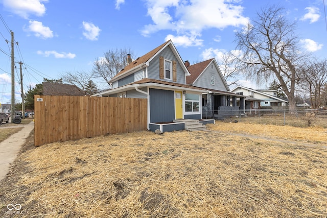 view of side of property with fence and a chimney